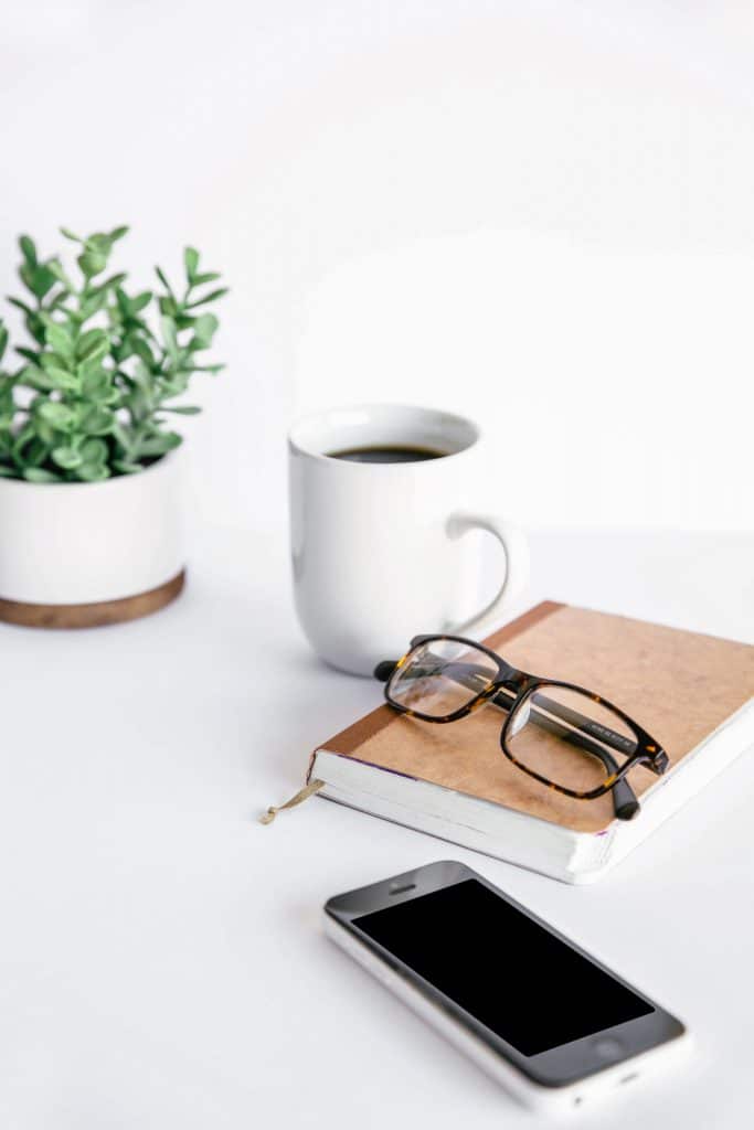 office supplies and glasses on white home office desk