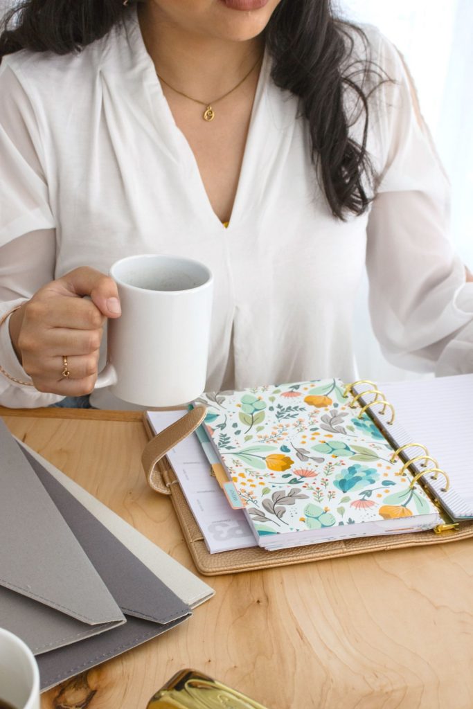 VA with white coffee cup and day planner