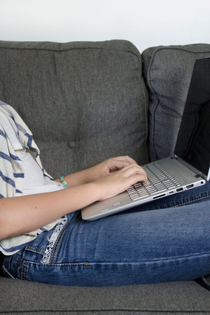 woman working from couch on laptop computer