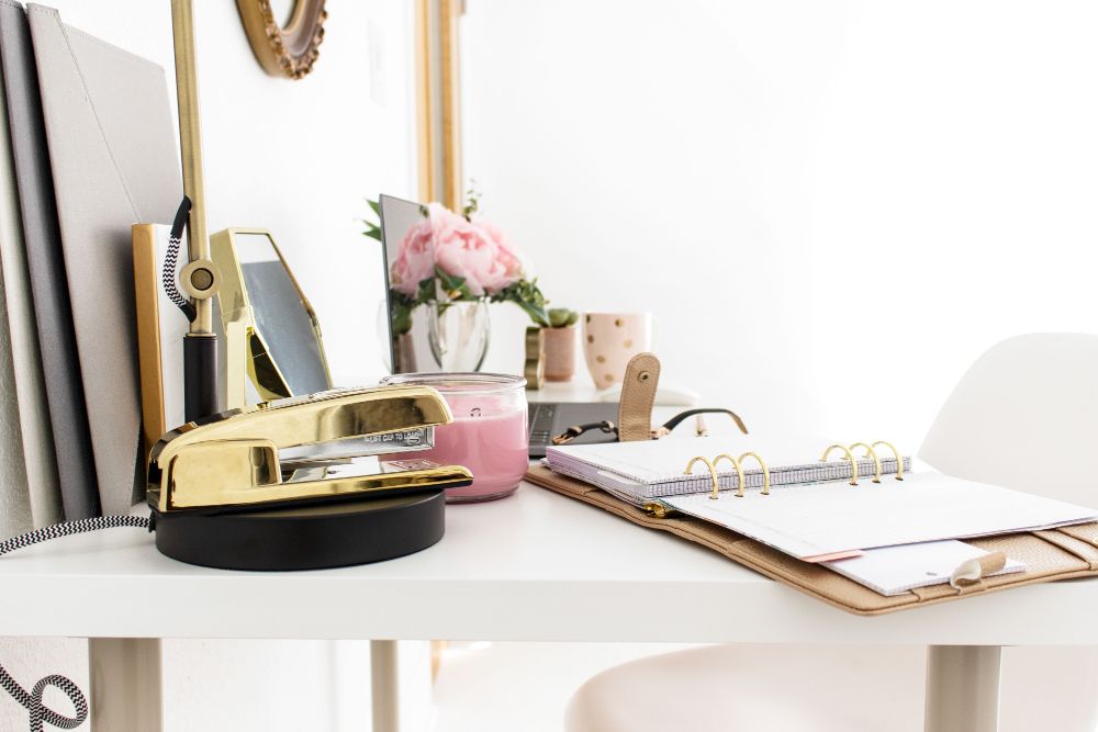 home office with planner and gold stapler on desk