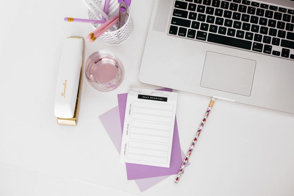 Laptop with desk accessories and notepad