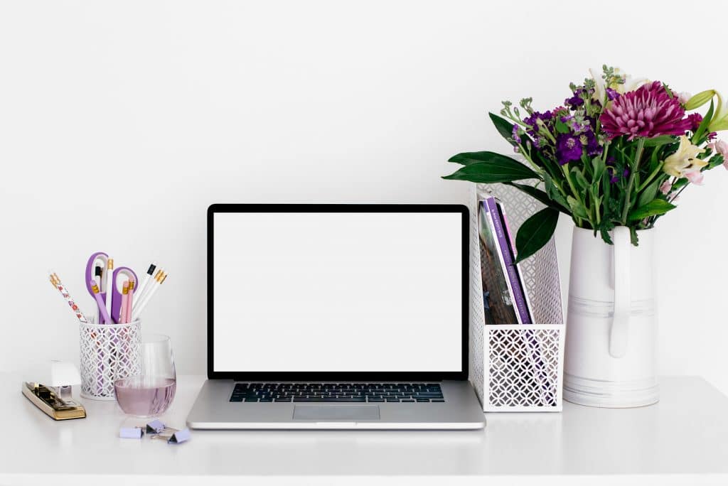 Laptop and flowers sitting on desk
