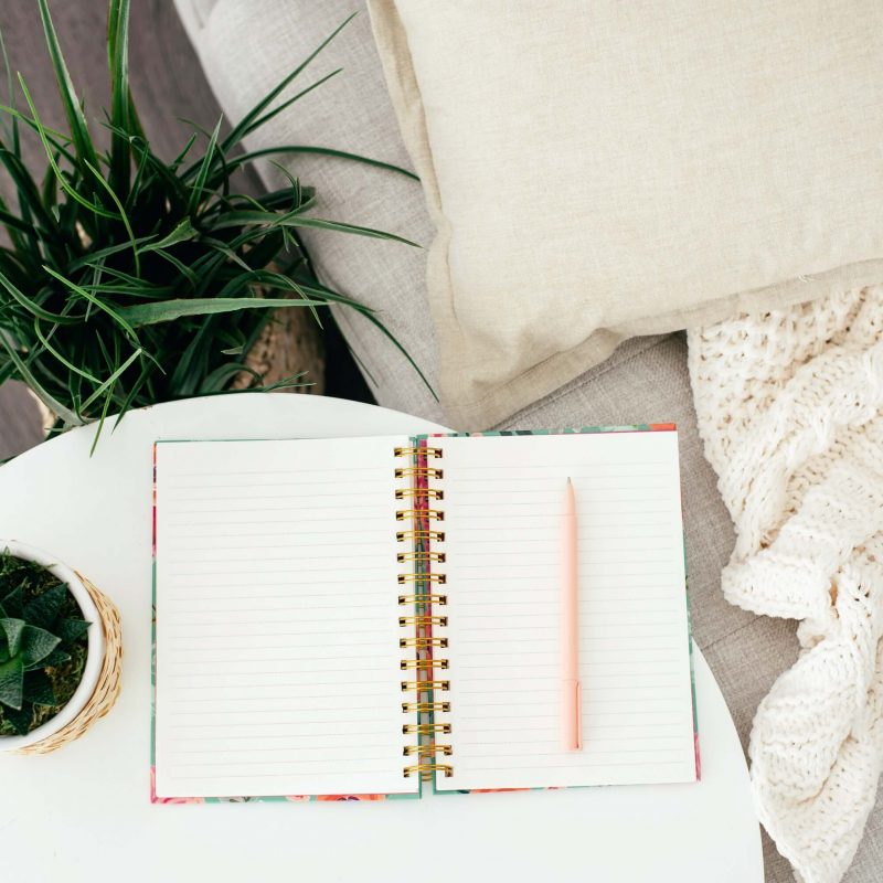 blank journal on side table with plants and sitting area