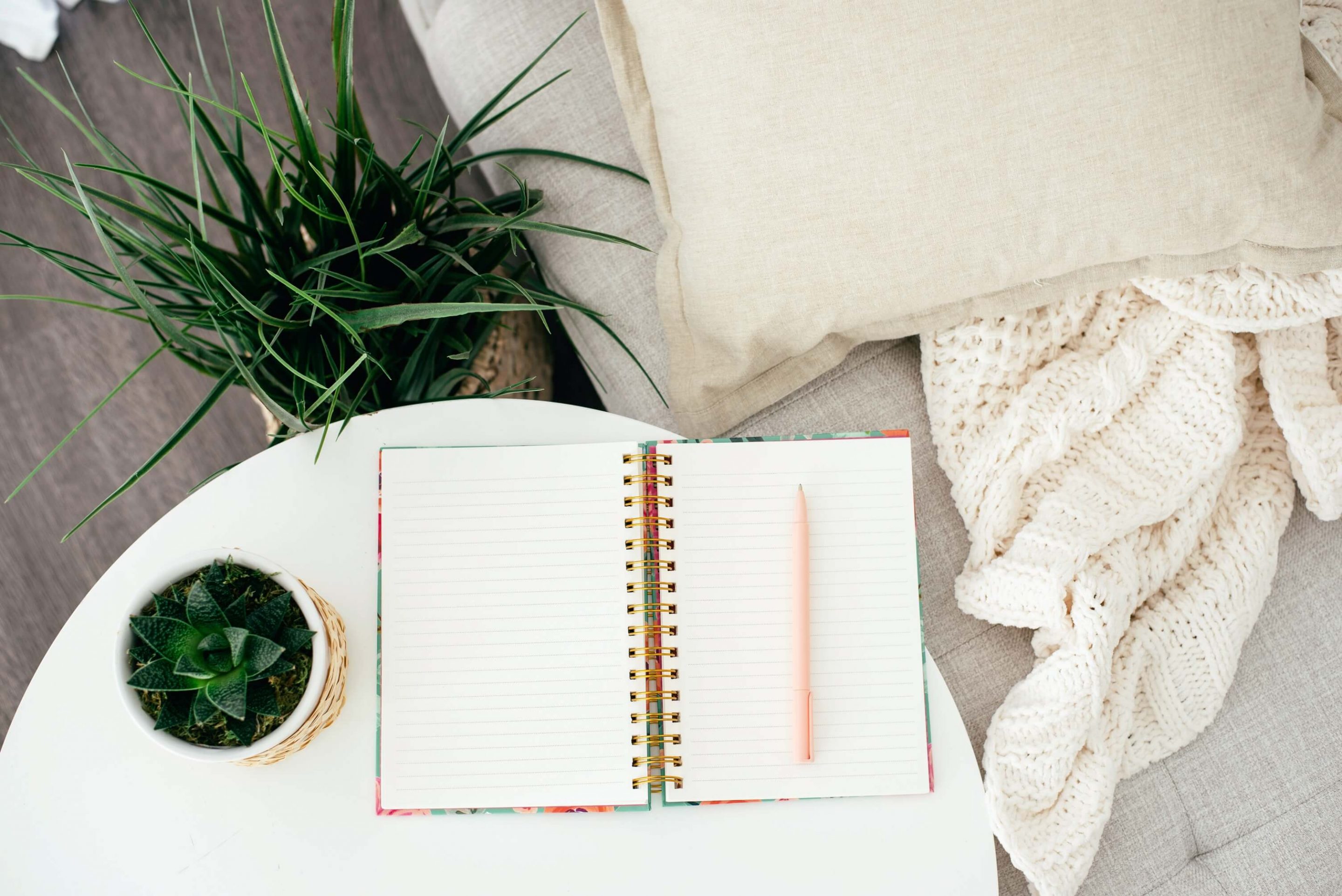blank journal on side table with plants and sitting area