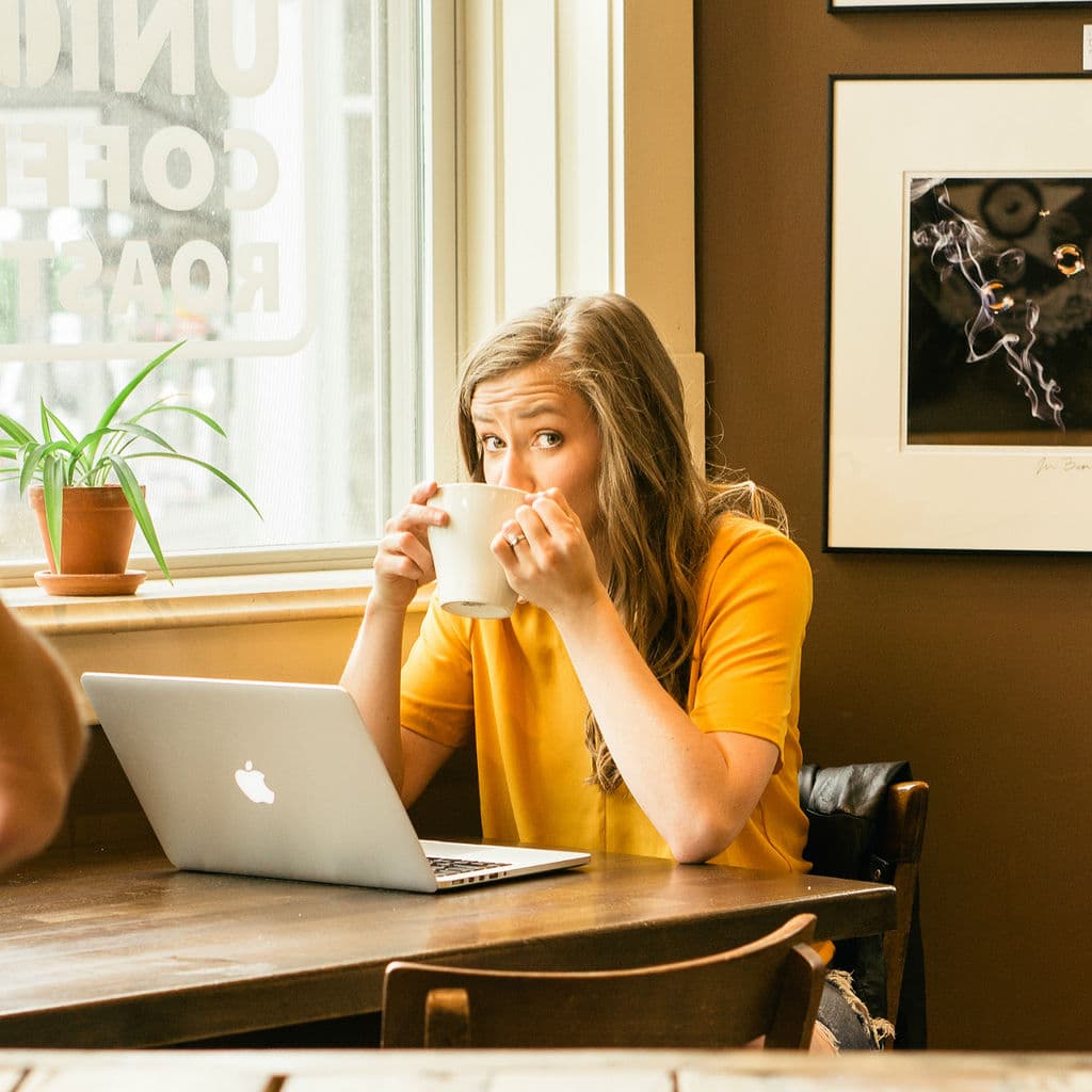 drinking coffee in coffee shop with laptop