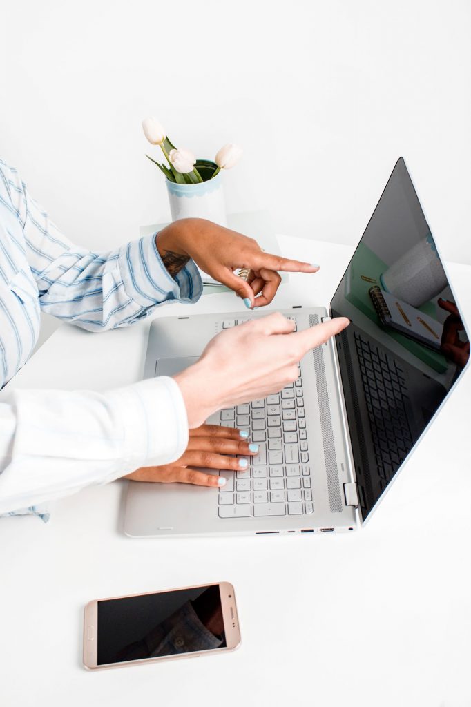 women pointing at laptop
