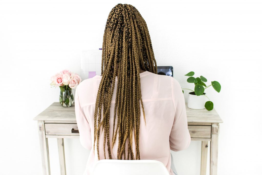 black woman facing the wall working at her desk.