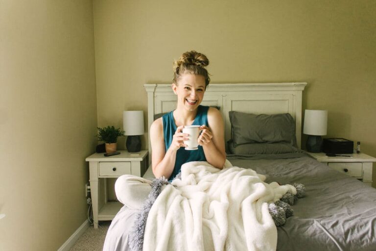chynna sitting on bed with blankets and coffee