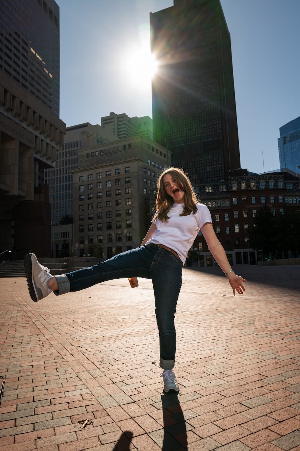 Chynna dancing on a brick walkway on a sunny afternoon holding a coffee