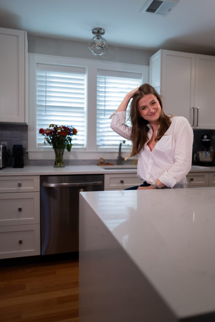 chynna benton sitting at a kitchen island smiling and flipping her hair