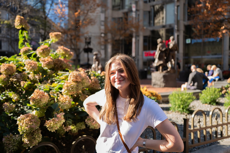 Chynna smiling with her hands on her hips by summer hydrangeas