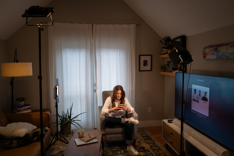 Chynna sitting in a chair in her living room during a photoshoot with lights around her
