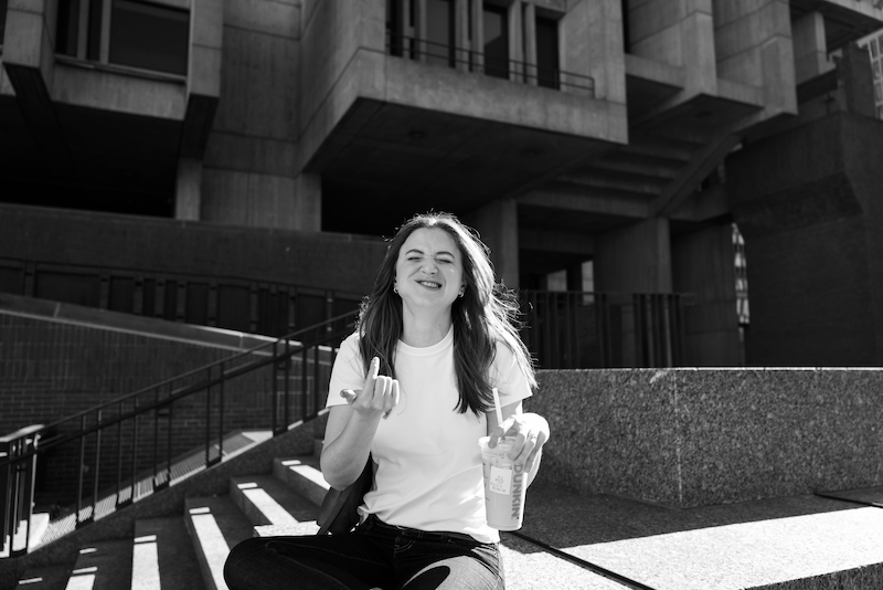 Chynna Benton sitting outside making a funny face smiling with a dunking cup