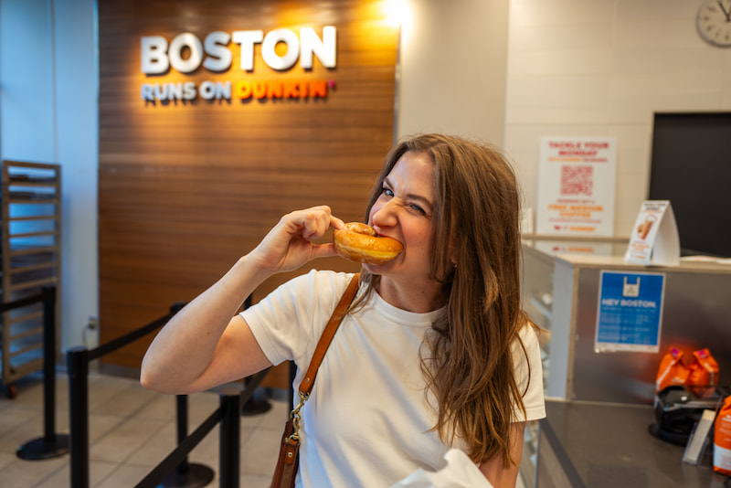 chynna benton eating a glazed donut in the boston dunkin donuts